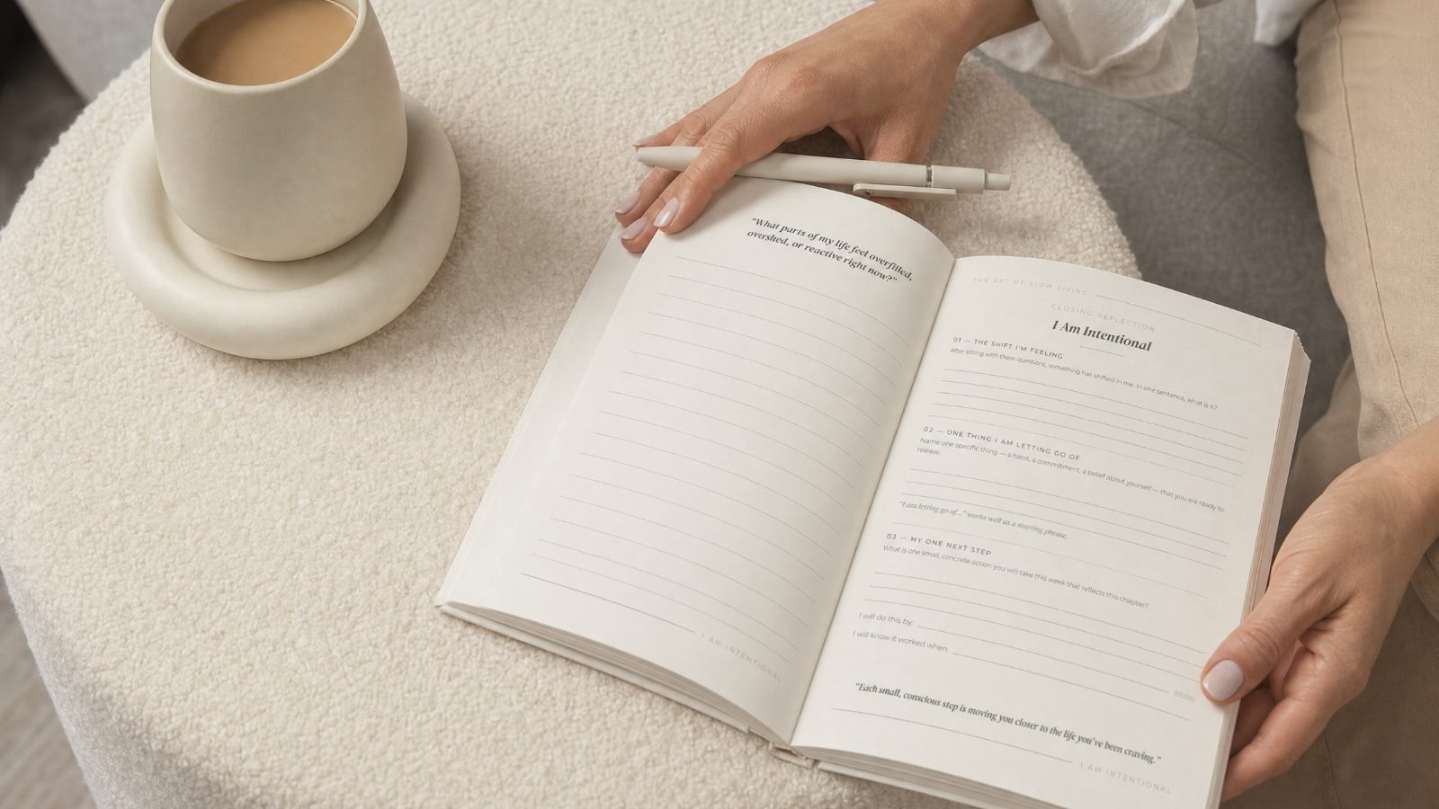 An open journal on a soft surface with a pen resting across it and a cup of coffee nearby, in warm morning light.